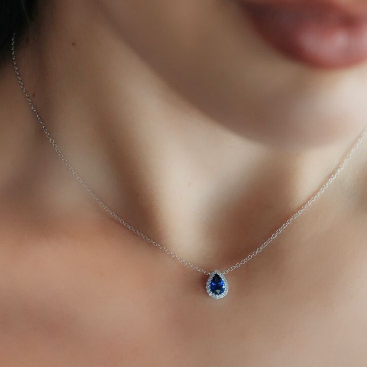 Indulge in tranquil beauty with this Pear-Shaped Blue Sapphire and Diamond Halo Necklace. It's perfect for gifting to a loved one (or yourself—no judgment here!). This piece really pops when paired with other sapphires from our Gemstone Collection. Natural Blue Sapphire: 0.80cts Natural Diamonds: 0.10ctw 18K White Gold Length: 16 Inches