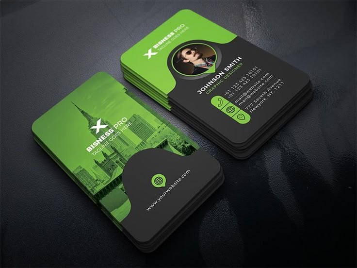 two green business cards sitting on top of a black table with an image of a woman