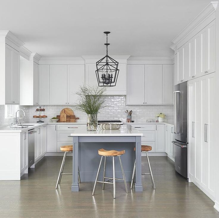 a kitchen with two stools at the center of the room and an island in the middle