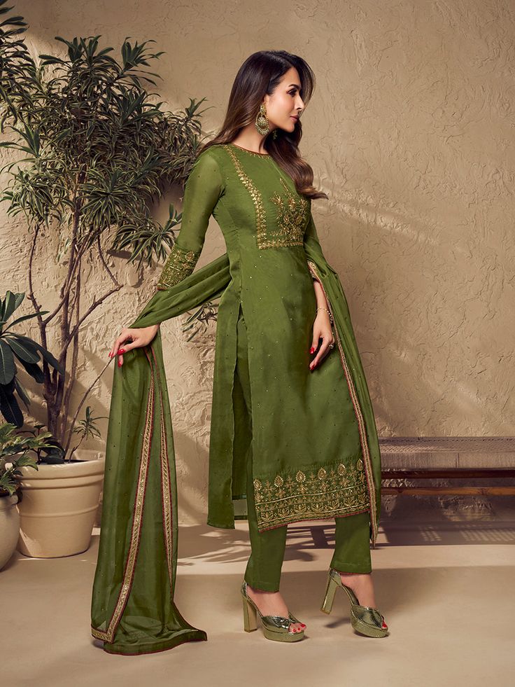 Defined by Malaika Arora's sense of fashion, this mehndi green kurta set is an epitome of grandeur and majestic artwork. Crafted using Zari work and mukaish embroidery, it features a straight top with three-quarter sleeves, a round neck and organza & shantu inner for comfort. The set includes a pair of cotton trousers and an organza dupatta with exquisite floral Zari machine weave yoke/border embroidery and taping. TOP: Organza, TOP INNER: Shantun, BOTTOM: Cotton, DUPATTA: Organza, Dry Clean Chanderi Churidar With Sheer Dupatta And Straight Kurta, Festive Dola Silk Kurta With Floral Embroidery, Green Semi-stitched Tissue Silk Churidar, Green Embroidered Tissue Silk Salwar Kameez, Embroidered Green Salwar Kameez In Tissue Silk, Green Embroidered Unstitched Tissue Silk Suit, Wedding Kurta With Floral Embroidery In Tissue Silk, Fitted Tissue Silk Anarkali Set With Floral Embroidery, Green Dola Silk Churidar With Sheer Dupatta