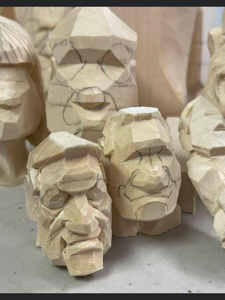 several carved wooden faces sitting next to each other