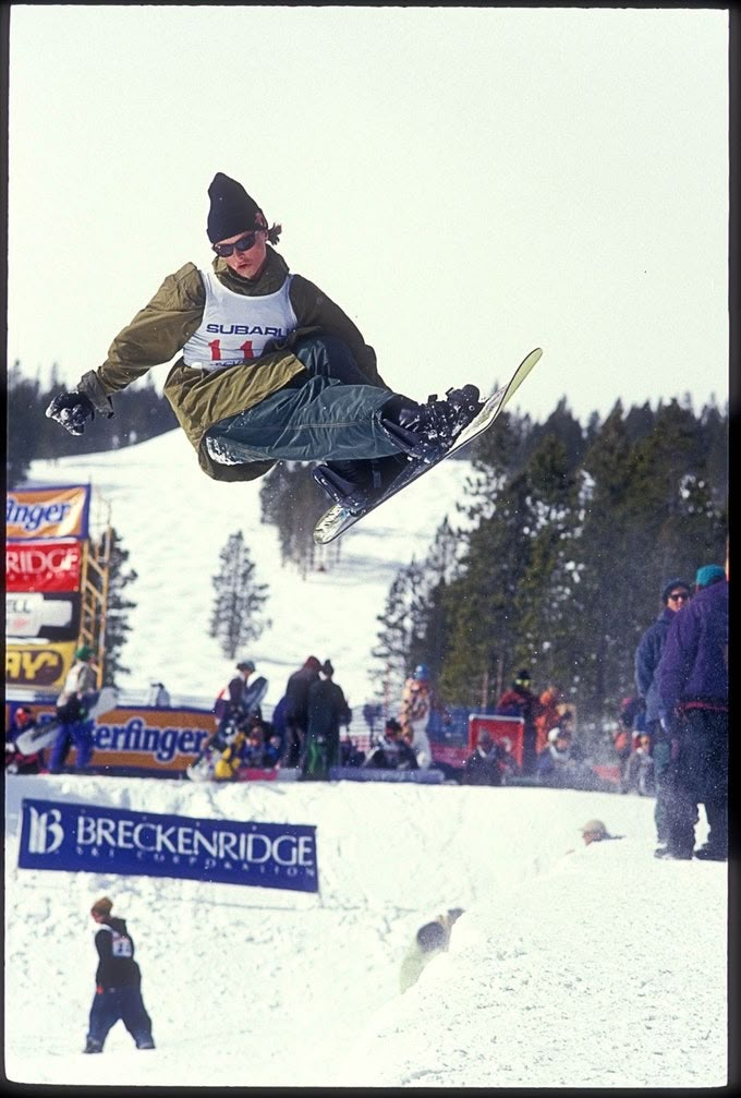 a man flying through the air while riding skis on top of snow covered ground