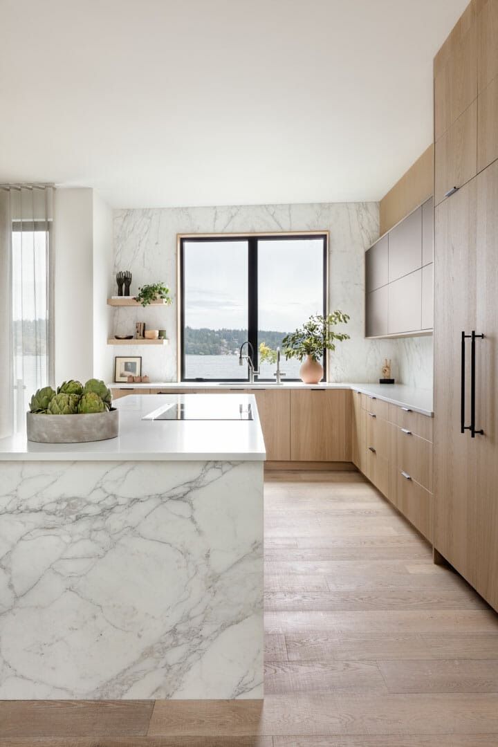 a large kitchen with marble counter tops and wooden cabinetry, along with an island in the middle