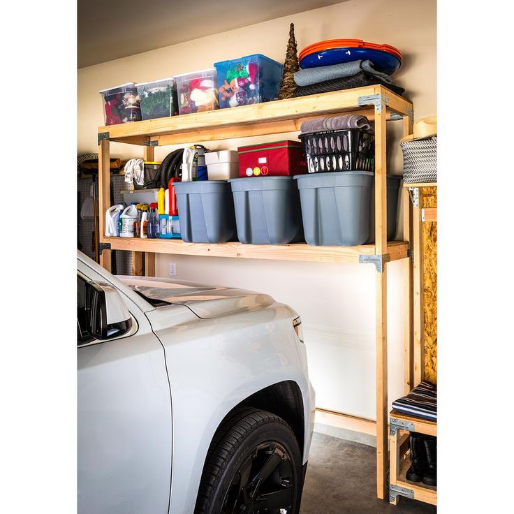 a car parked in front of a shelf filled with plastic containers and other items on top of it