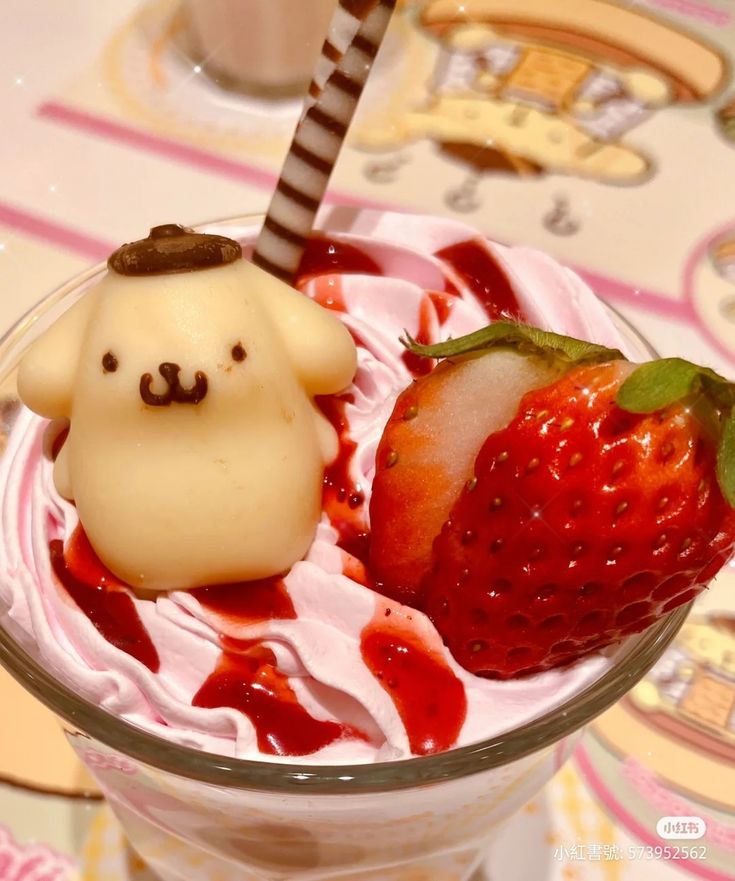 a dessert with strawberries and ice cream in a glass on top of a table