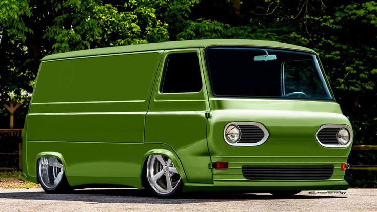 a green van is parked in front of some trees