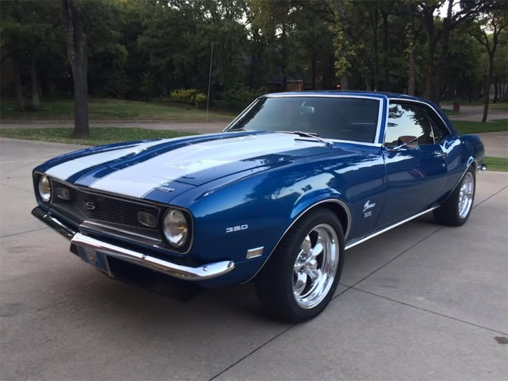 a blue muscle car parked in a driveway