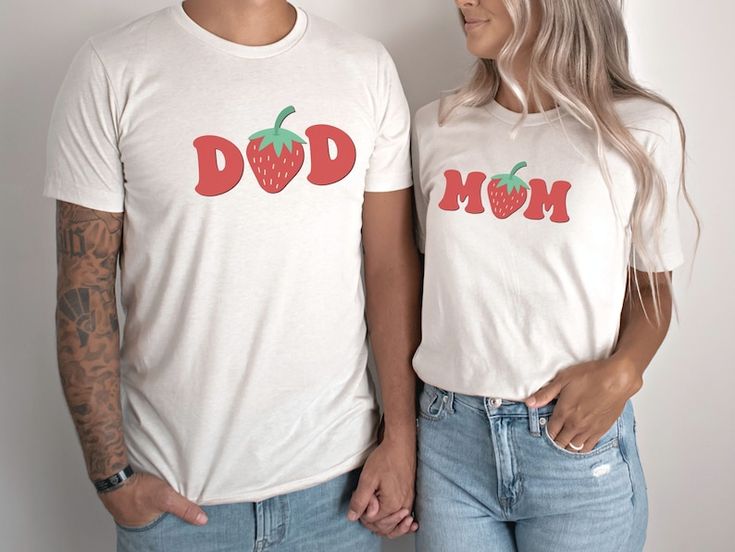 a man and woman standing next to each other wearing matching shirts with strawberries on them