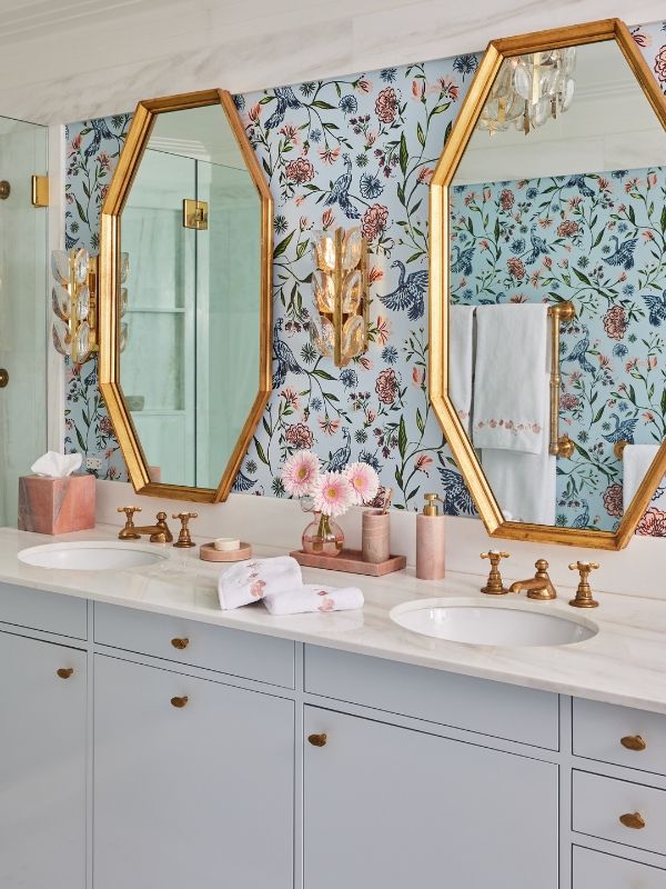 two sinks and mirrors in a bathroom with floral wallpaper