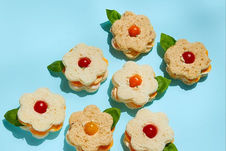 small sandwiches with jelly on them are arranged in the shape of flower petals and leaves