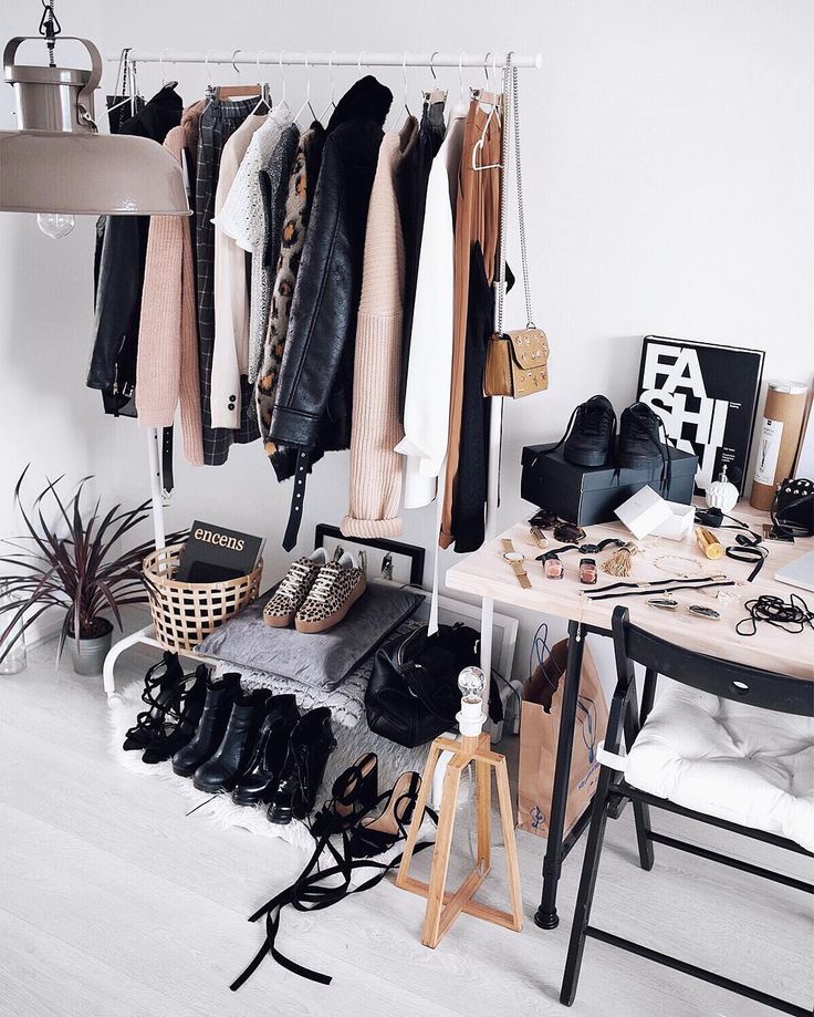 an organized closet with clothes and shoes hanging on the rack, along with other items