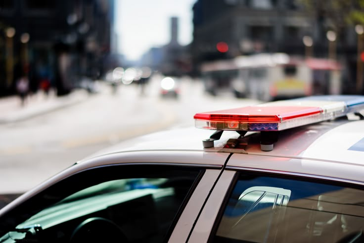 a police car is parked on the side of the road with its lights on and flashing