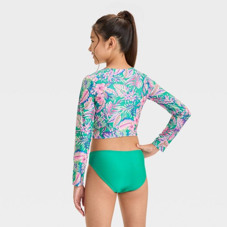 Add a touch of tropical style with the Abstract Tropical Jungle Flowers Bikini Set from art class™. This three-piece bikini set includes a bikini top and long-sleeve rash guard with an abstract tropical print, plus a solid green bikini bottom to complete the look. Made from recycled polyester with stretchy spandex, this swimwear set offers comfort during waterside activities. Plus, with a UPF 50+ rating, these pieces help keep their skin shielded from the sun's rays. art class™: One-of-a-kind lo Jungle Flowers, Teen Summer, Solid Green, Swimwear Sets, Tropical Style, Coral Orange, Kids Outfits Girls, Pair Of Pants, Swimwear Fashion