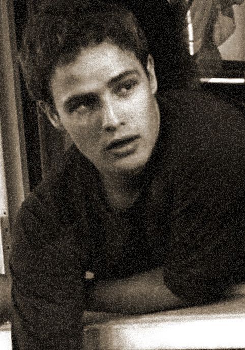 black and white photograph of a young man leaning on stairs