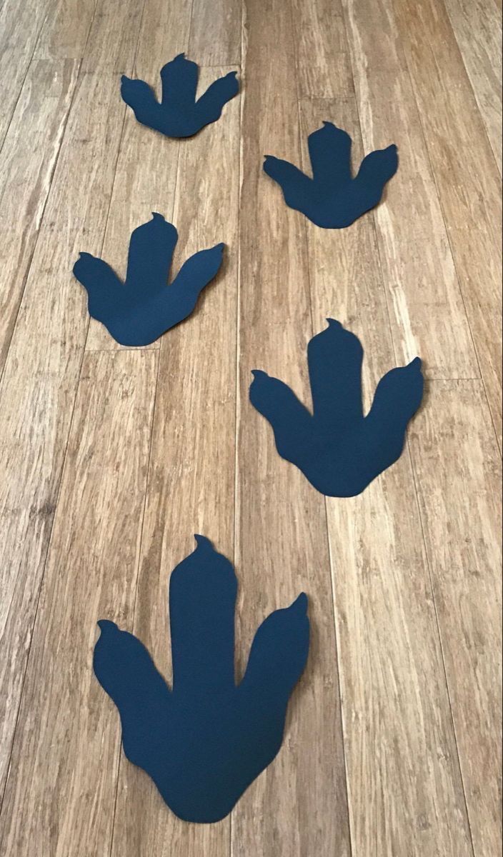 three blue paper cut outs sitting on top of a wooden floor