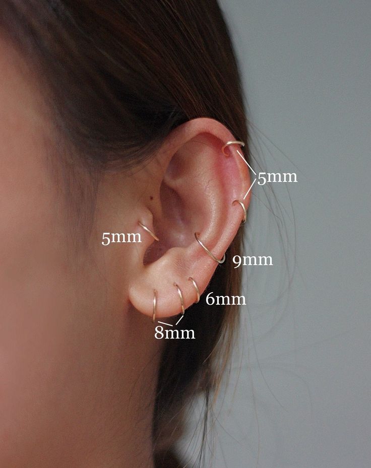 a woman's ear is shown with three different piercings on the end of it