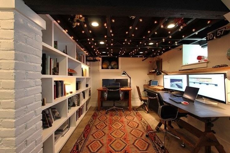 a home office with two computer desks and bookshelves on either side of the room