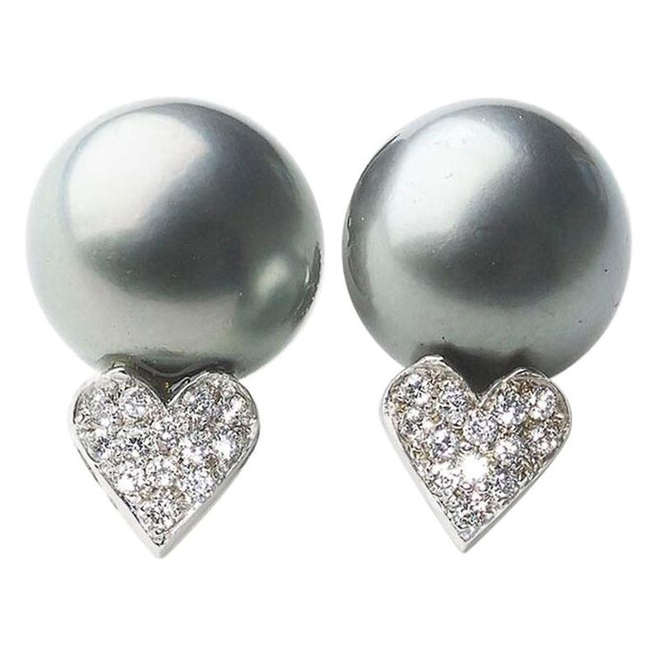 A pair of Tahitian black pearl and diamond earrings, with a pair of Tahitian black pearls, measuring approximately 12.9mm and 13.5mm respectively, each with a heart below, pavé set, round brilliant-cut diamonds, mounted in 14ct white gold, with posts and butterfly backs, circa 1990. Tahitian Pearl Earrings, Sapphire And Diamond Earrings, Vintage Stud Earrings, Diamond Cluster Earrings, Pearl And Diamond Earrings, White Gold Earrings, Earrings 3, Antique Earrings, Pearl Diamond