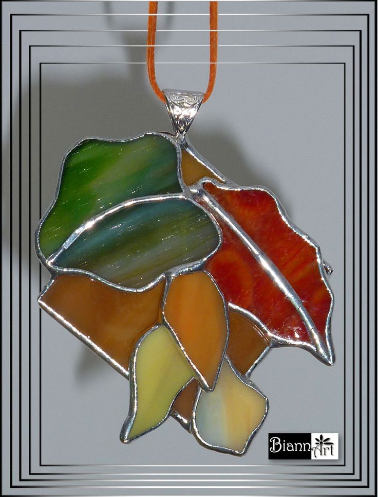 a multicolored stained glass leaf pendant hangs from a cord