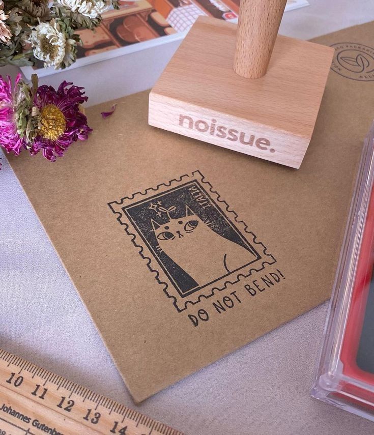 a rubber stamp with a cat on it next to some flowers