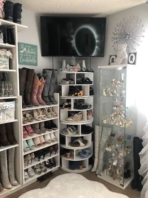 there is a large television in the corner of this shoe rack with many pairs of shoes on it