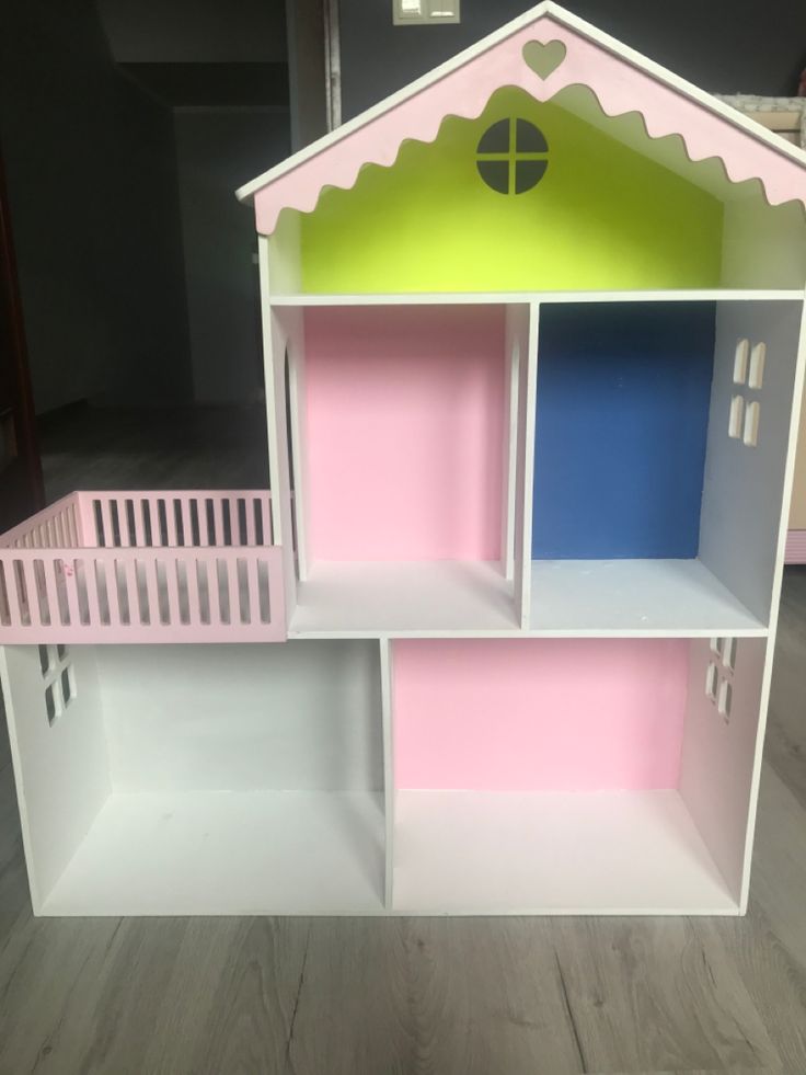 a pink and white doll house with stairs