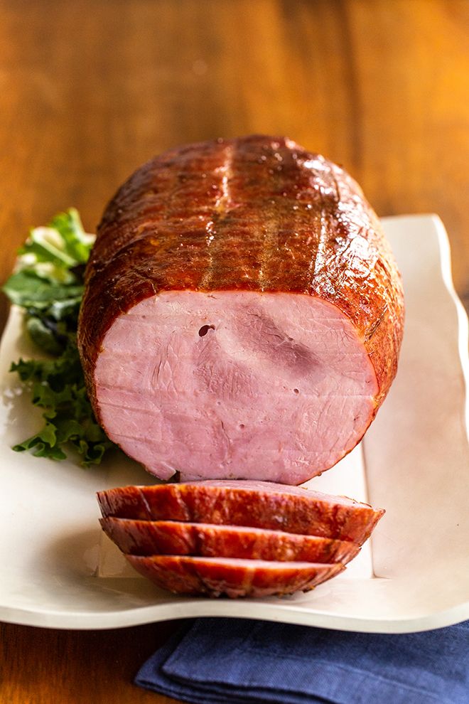 a ham on a plate with parsley next to it