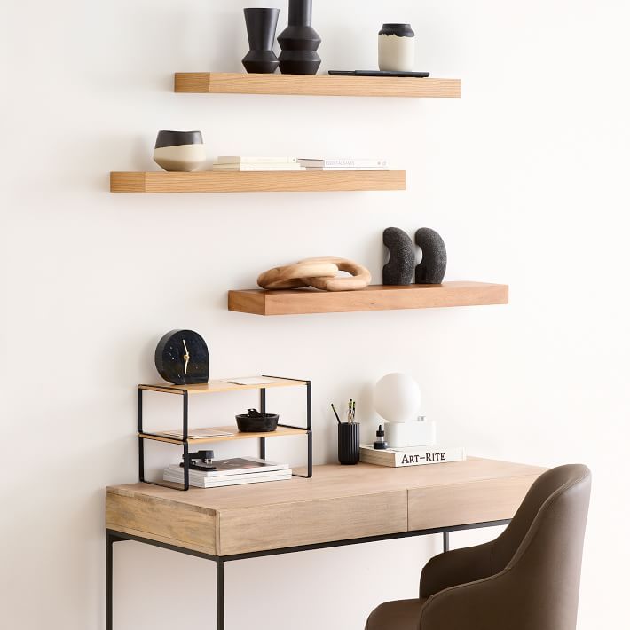 a desk with two shelves on the wall above it and a chair next to it