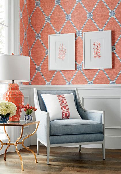 a living room with orange and blue wallpaper on the walls, two chairs and a coffee table