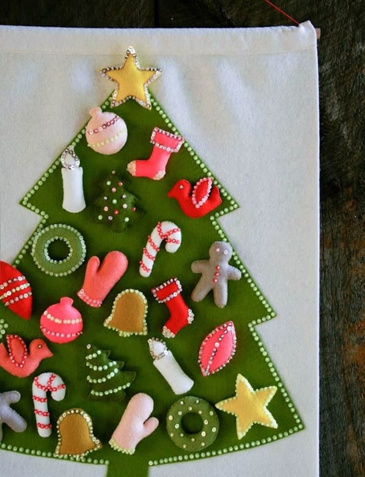 a christmas tree made out of felt on top of a piece of white paper with green trim