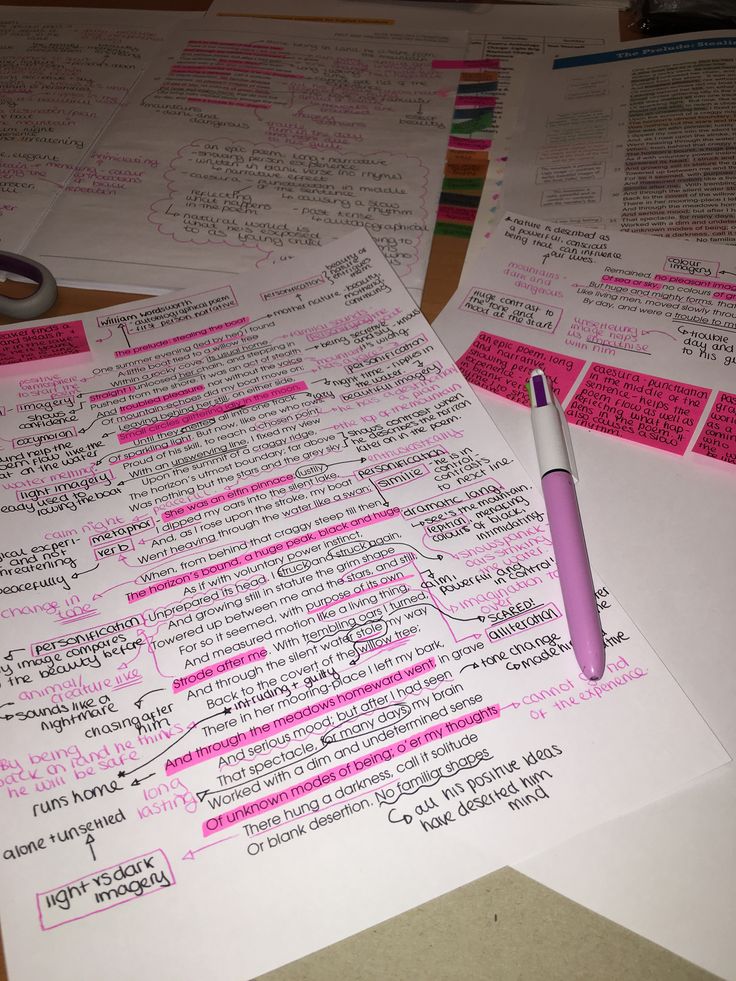 several papers with writing on them and a pen resting on top of one paper that has been written in pink ink