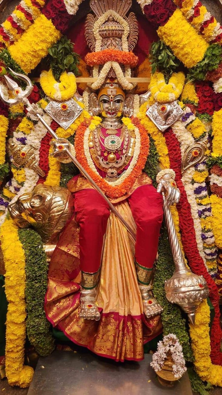 an idol is displayed with flowers and other decorations