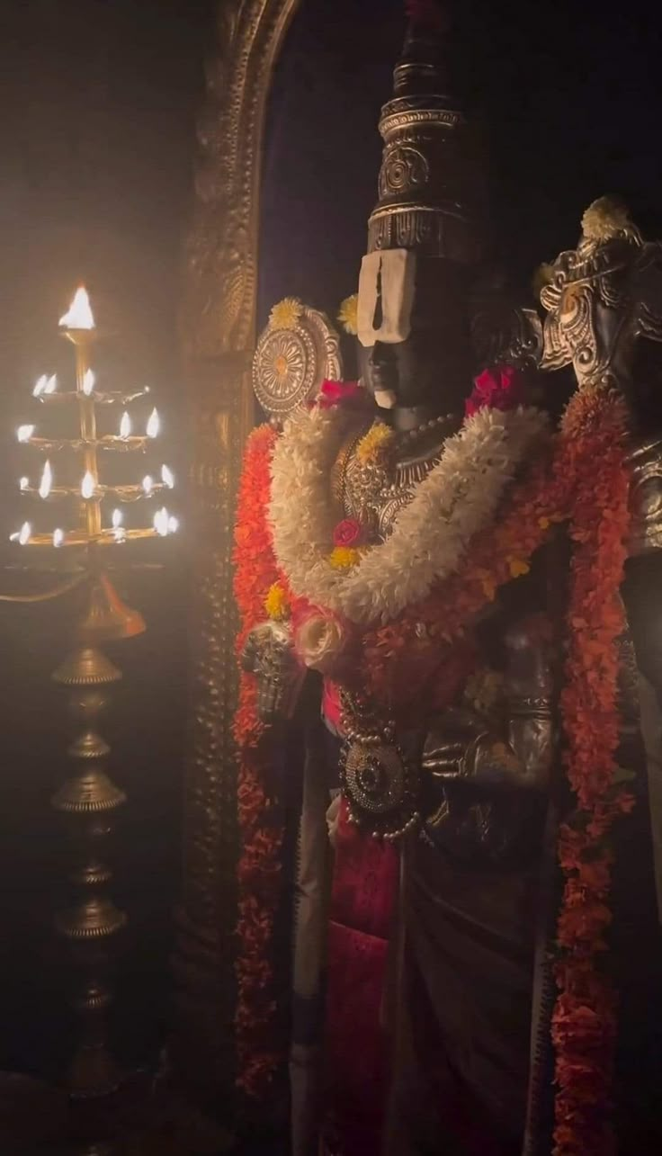 the statue is decorated with flowers and candles