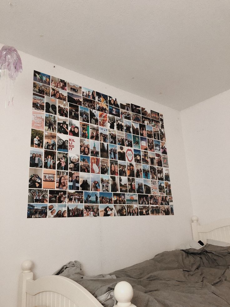 a bed sitting under a wall covered in pictures