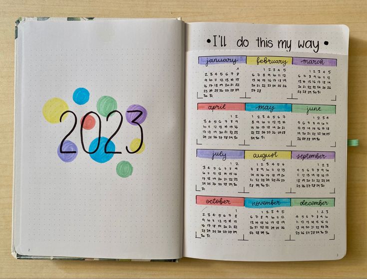 an open notebook with a calendar on the page and numbers written in colored markers