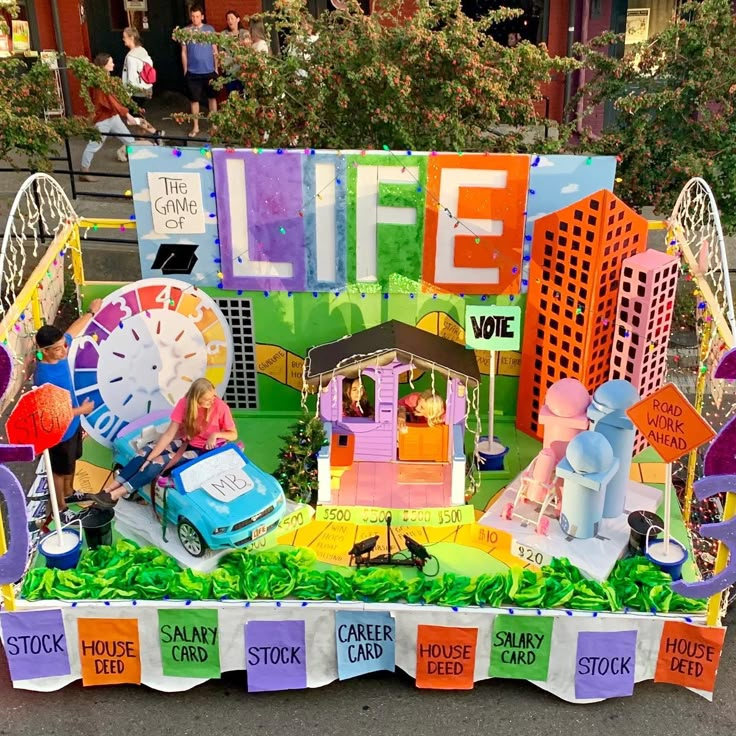 a parade float with people sitting on it's sides and writing life above them