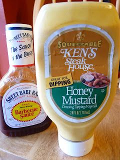 two bottles of honey mustard sitting on top of a wooden table