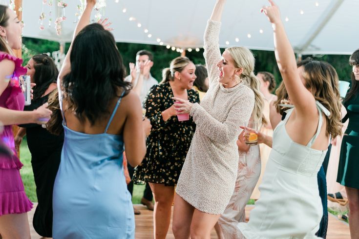 a group of women standing around each other at a party