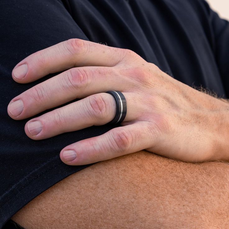 a close up of a person's hand with a ring on his left wrist