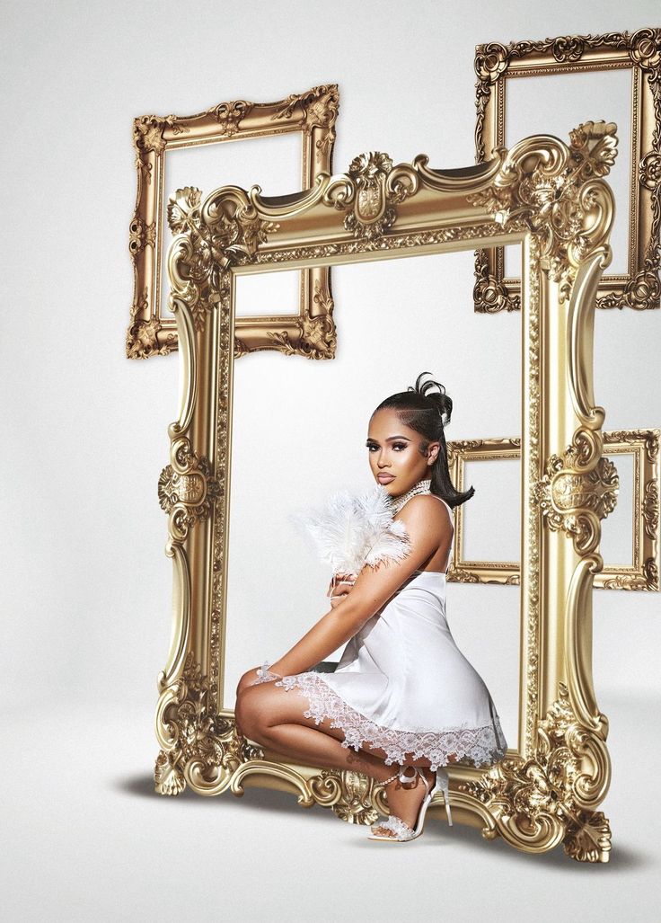 a woman posing in front of a gold frame