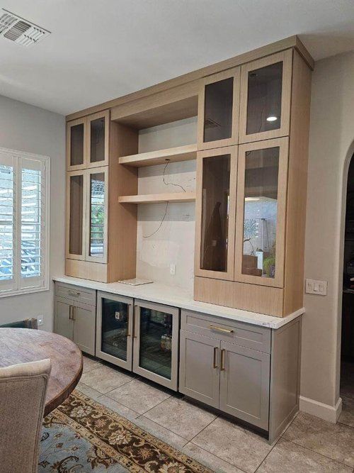 a kitchen with an oven, cabinets and a dining room table in the middle of it