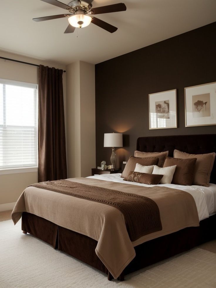 a bedroom with a bed, ceiling fan and two pictures on the wall above it