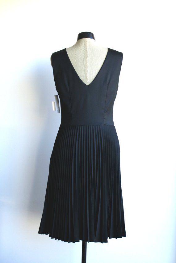 Black pleated dress. Sleeveless. Decorative folds on neckline. Zip on left side. With lining. Dress is made of black fabric.Size 38/8/S (bust 92cm/36,2in, waist 74cm/29,1in, hips 98cm/38,6in)Back lenght 105cm75%PL 25%Ray  2%EAlining 50%PL 50%RayDry cleaning Elegant Black Pleated Dress With Accordion Pleats, Black A-line Dress With Accordion Pleats, Classic Pleated Hem Dress For Party, Classic Pleated Dress For Parties, Elegant Fitted Sleeveless Pleated Dress, Black Sleeveless Dress With Accordion Pleats, Classic Black Pleated Dress For Formal Occasions, Classic Black Pleated Dress For Formal Events, Formal Stretch Dress With Pleated Back