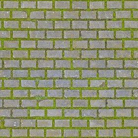 a red fire hydrant sitting on the side of a brick wall covered in grass