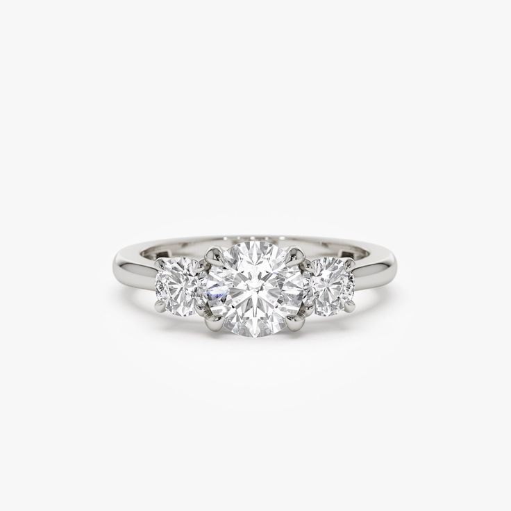 three stone engagement ring in white gold with diamonds on the sides and an oval diamond center