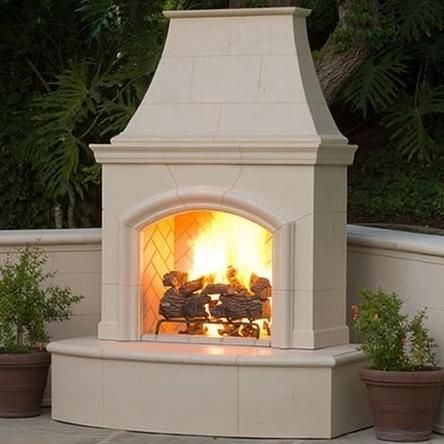 an outdoor fireplace with potted plants around it