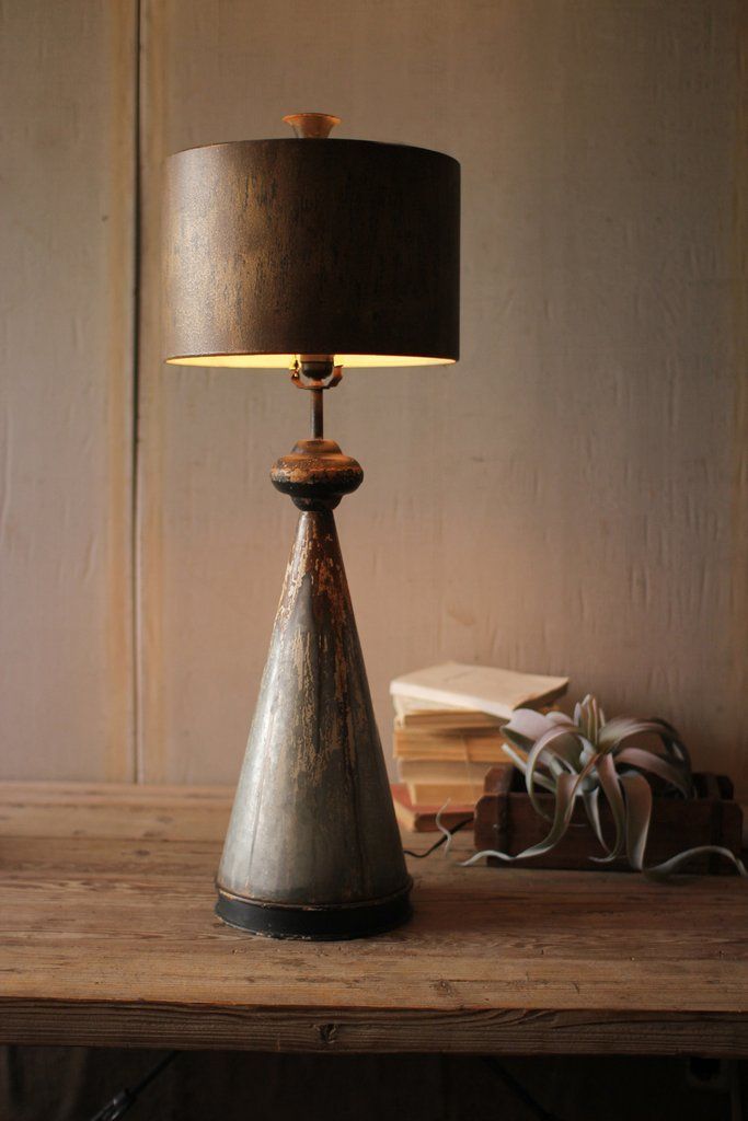 a lamp that is sitting on top of a table next to a book case and some books