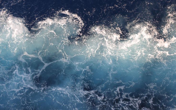 an aerial view of the ocean with waves and foamy blue water, taken from above