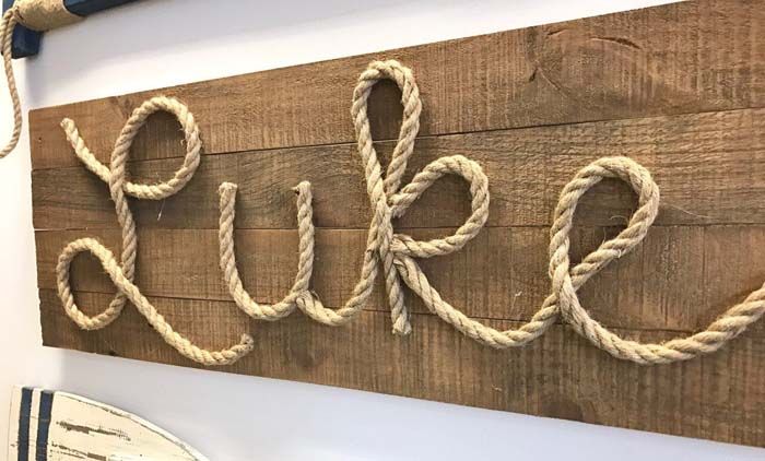 a wooden sign with rope hanging from it's sides and the word pure written in large letters