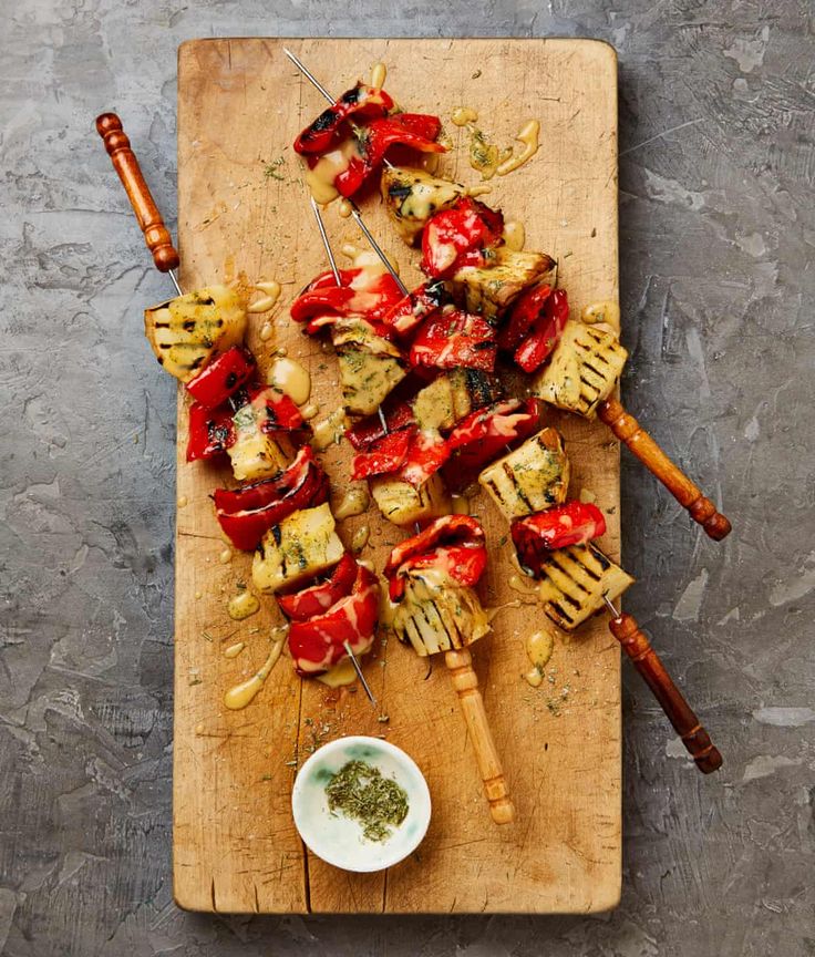 skewered meat and vegetables on a wooden cutting board